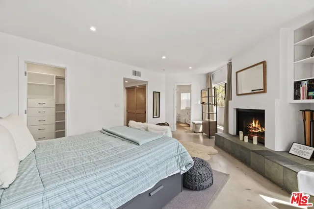 a spacious bedroom with a bed and a fireplace
