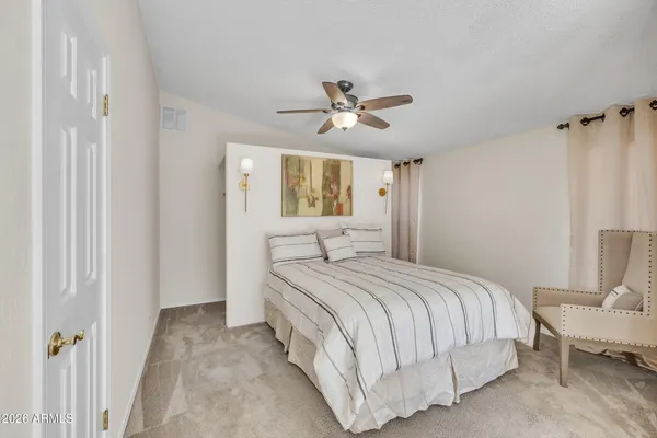 a spacious bedroom with a large bed and a chandelier