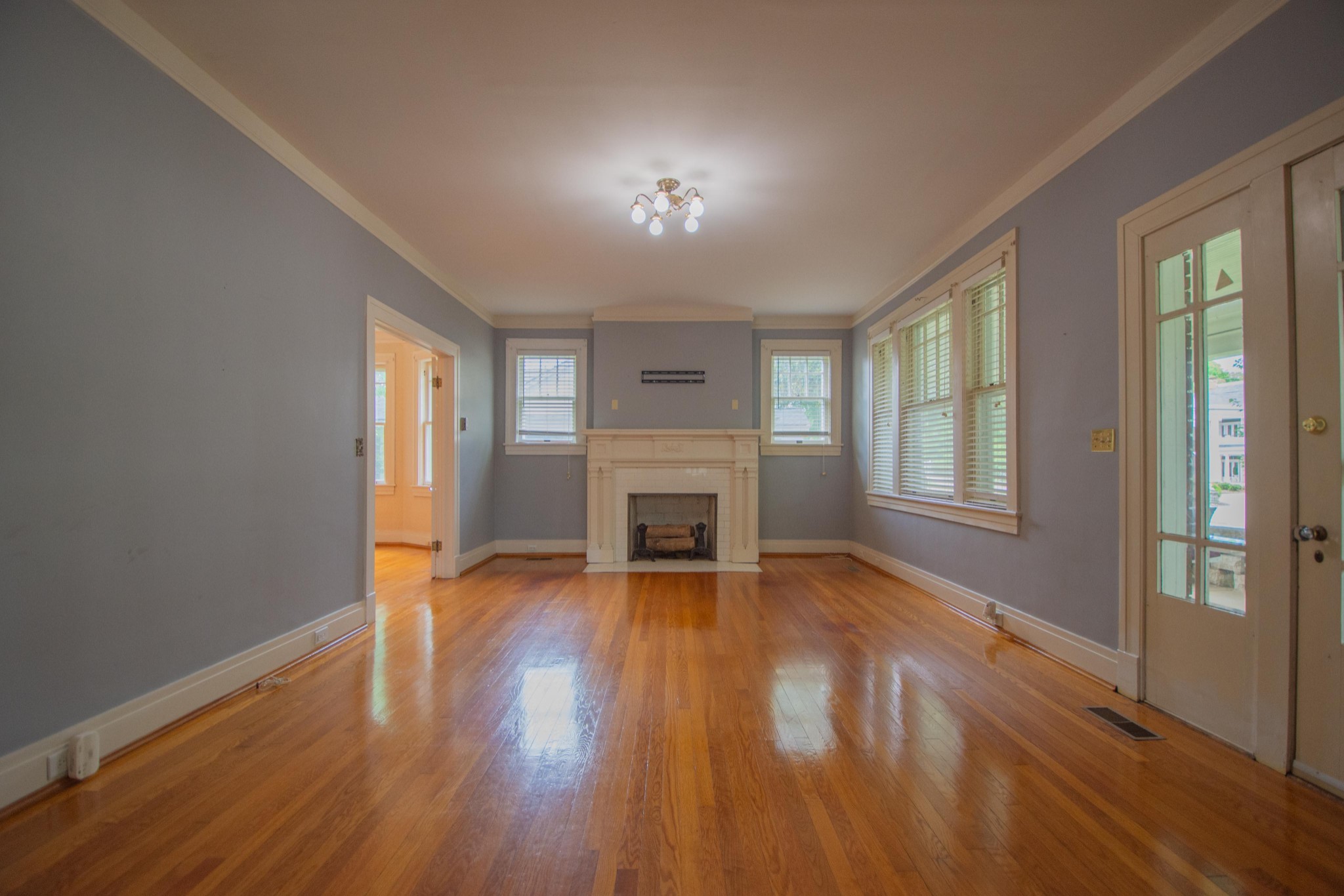 311 South 3rd Street Pulaski, TN 38478 - Photo 14 of 44 an empty room with wooden floor fireplace and windows