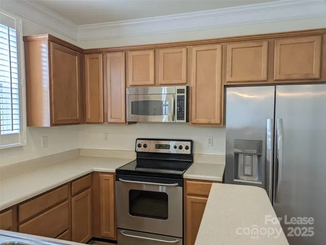 a kitchen with stainless steel appliances granite countertop a refrigerator stove and sink
