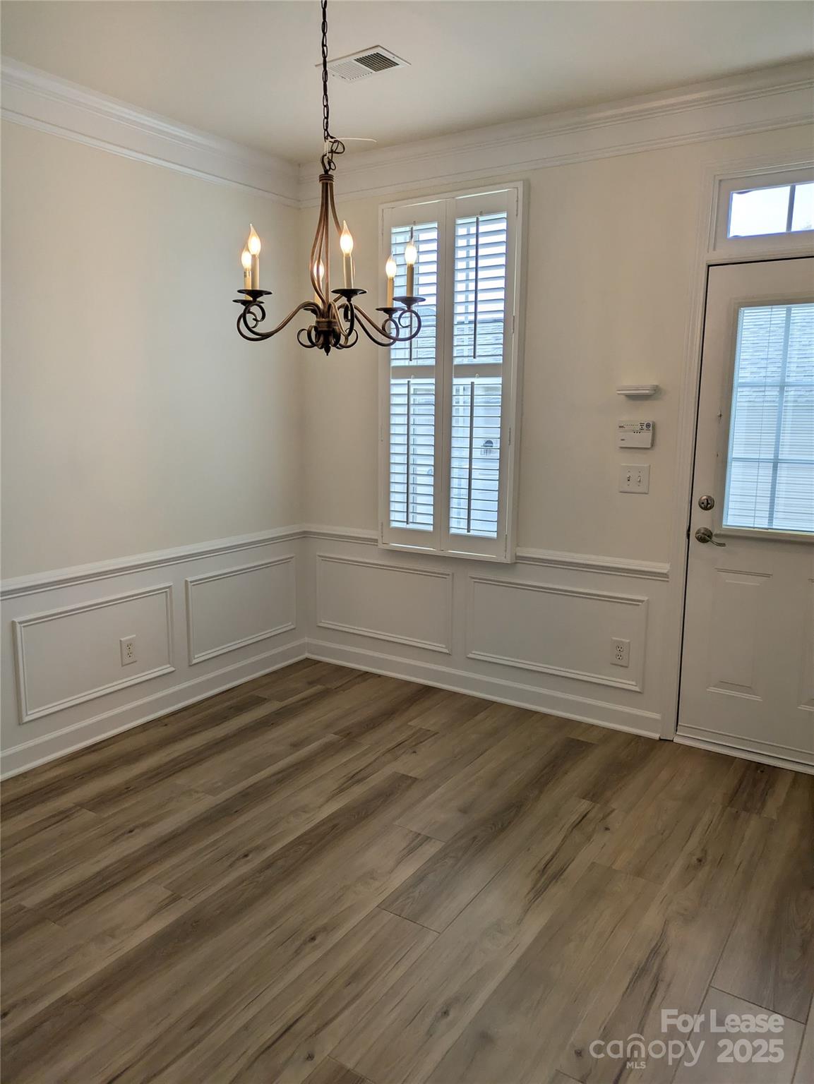 103 Chawton Lane Mooresville, NC 28117 - Photo 13 of 31 an empty room with wooden floor cabinet and windows