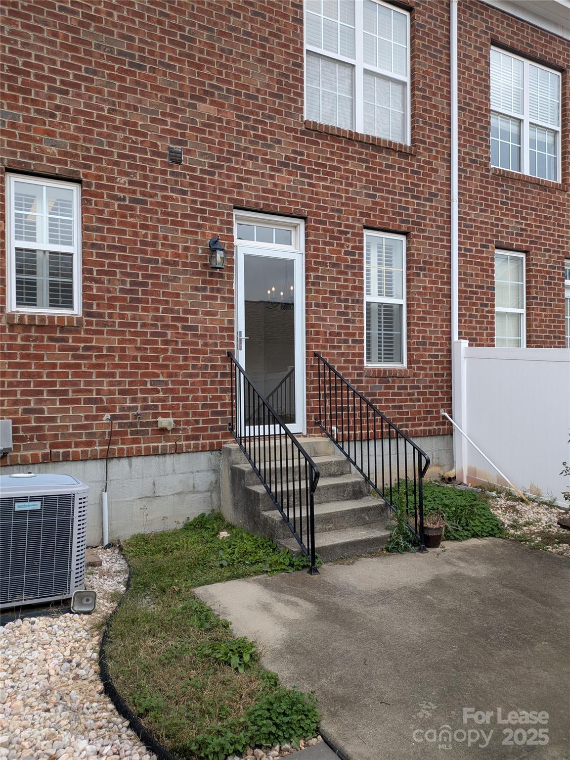 103 Chawton Lane Mooresville, NC 28117 - Photo 27 of 31 a brick house with a small yard and wooden fence