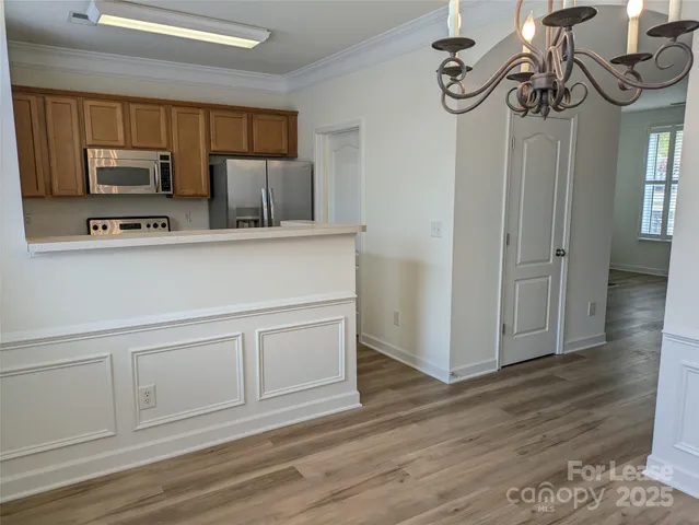 a kitchen with stainless steel appliances granite countertop a sink a stove a microwave and wooden floors