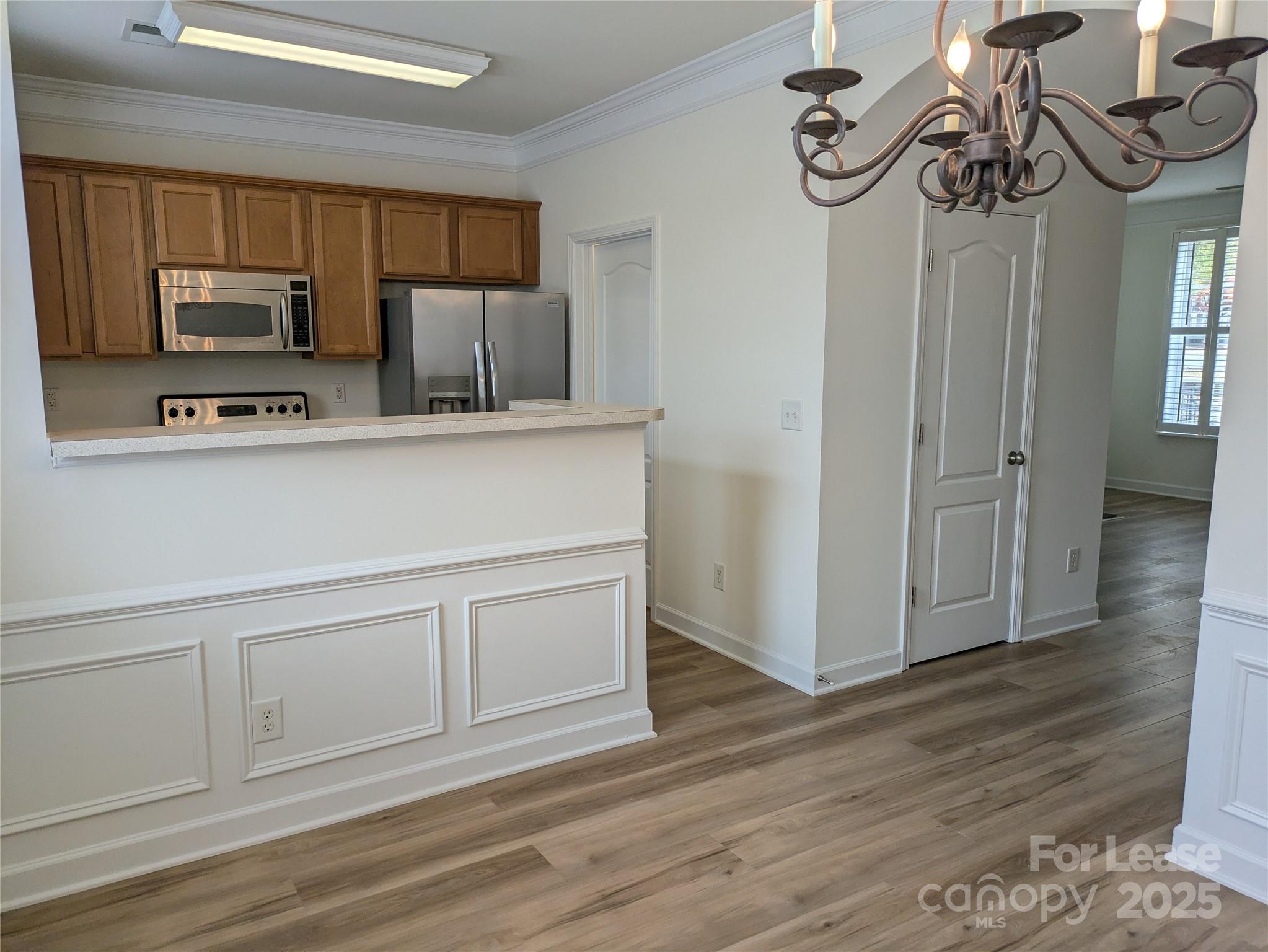 103 Chawton Lane Mooresville, NC 28117 - Photo 9 of 31 a kitchen with stainless steel appliances granite countertop a sink a stove a microwave and wooden floors