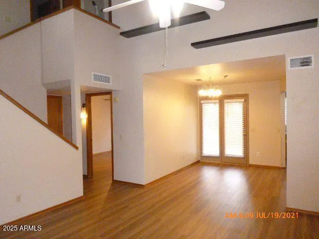 a view of a big room with wooden floor and windows