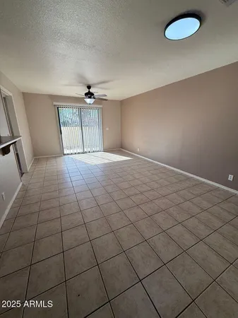 an empty room with windows and ceiling fan