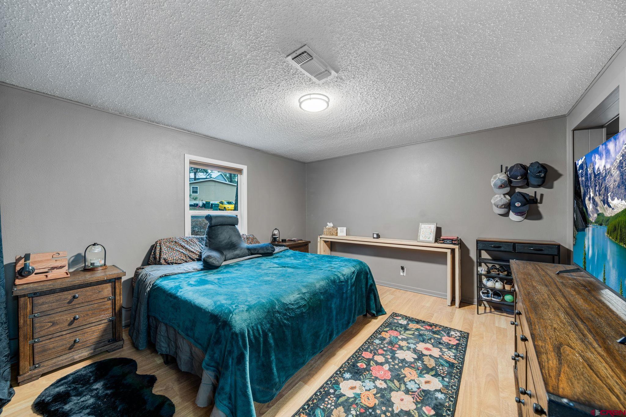 199 Timber Drive Durango, CO 81303 - Photo 16 of 29 a bedroom with a bed and wooden floor