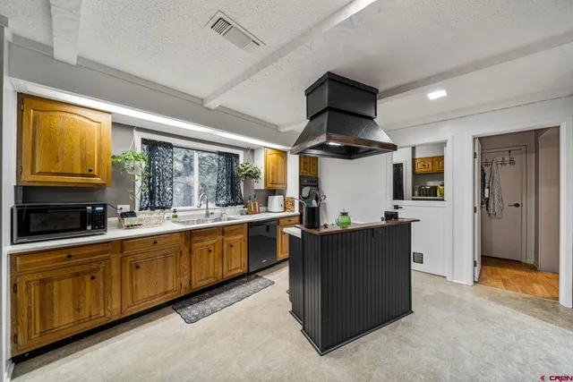 a kitchen with stainless steel appliances granite countertop sink stove and refrigerator