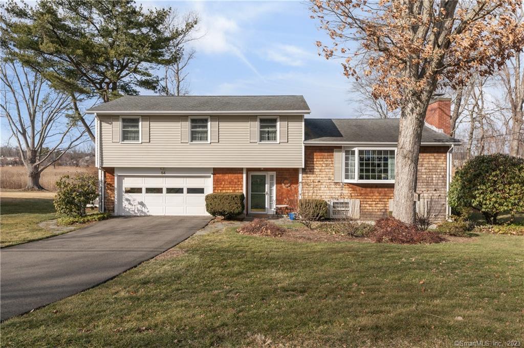 54 Riverside Drive Branford, CT 06405 - Photo 1 of 1 a front view of a house with yard outdoor seating and garage