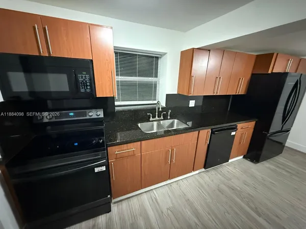 a kitchen with granite countertop wooden cabinets and a stove top oven