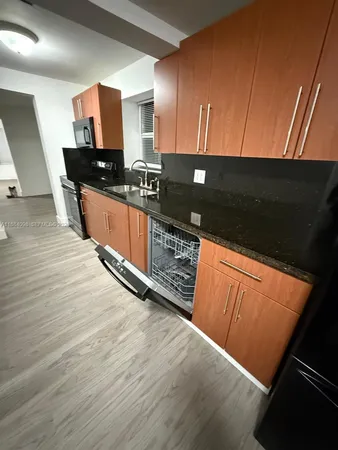 a kitchen with stainless steel appliances kitchen island granite countertop a stove a sink and a microwave