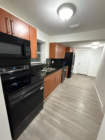 a kitchen with sink a microwave a stove and cabinets