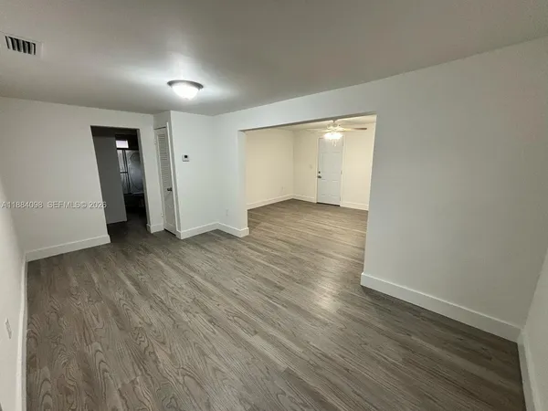an empty room with wooden floor and closet