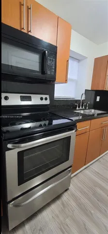 a kitchen with granite countertop a stove and a microwave