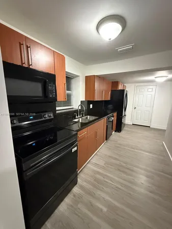 a kitchen with stainless steel appliances kitchen island granite countertop a stove a sink and a microwave