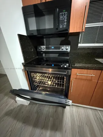 a kitchen with stainless steel appliances a refrigerator and wooden floor