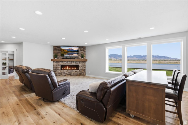 21 Pier Place Tooele, UT 84074 - Photo 49 of 112 Open-concept living space featuring a stacked stone fireplace with a wood mantle, a linear gas firebox, and recessed ceiling lighting