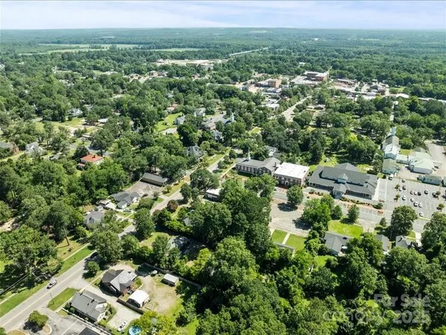 an aerial view of residential houses with outdoor space and trees