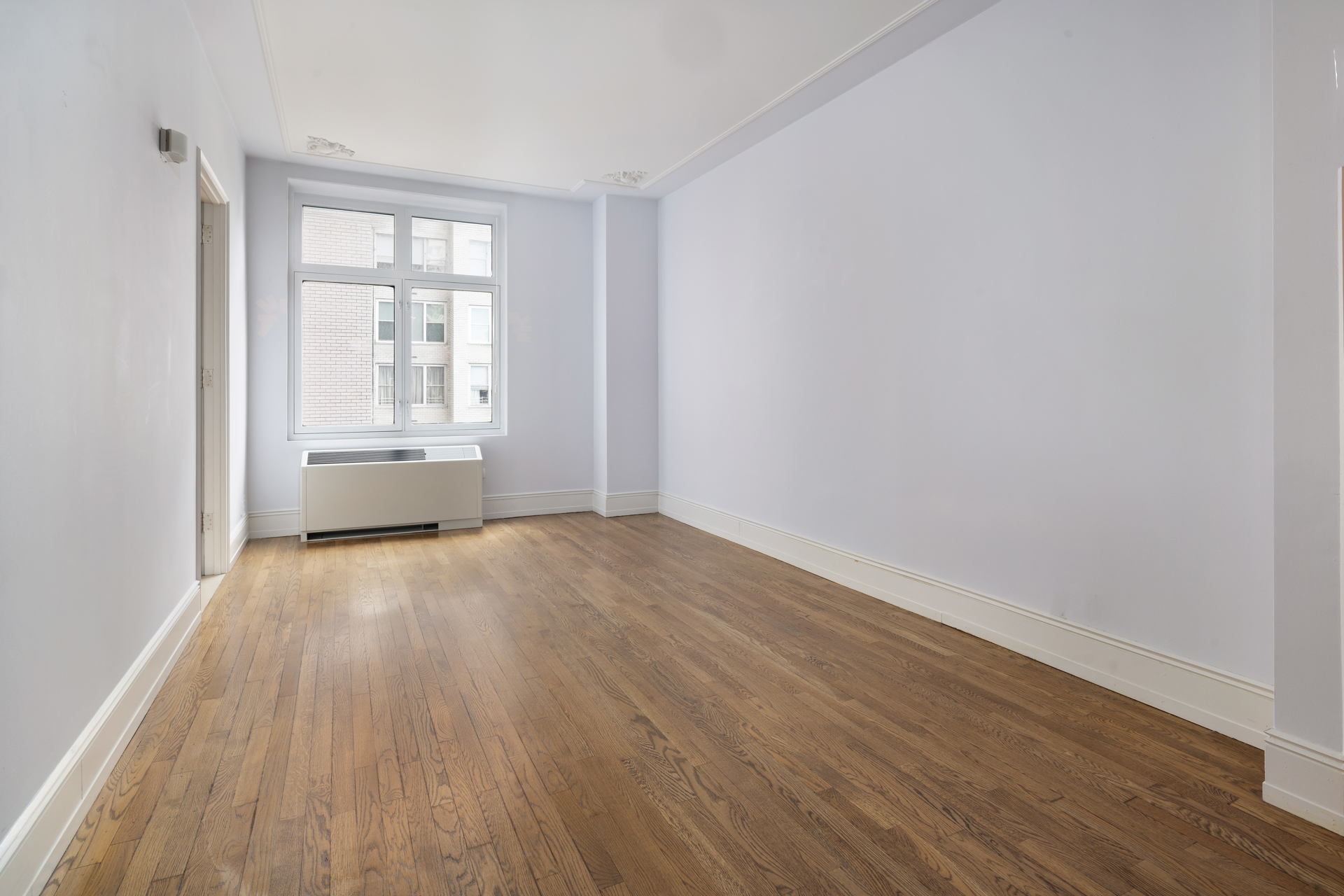 188 East 70th Street, Unit 11D Manhattan, NY 10021 - Photo 10 of 14 an empty room with wooden floor and windows