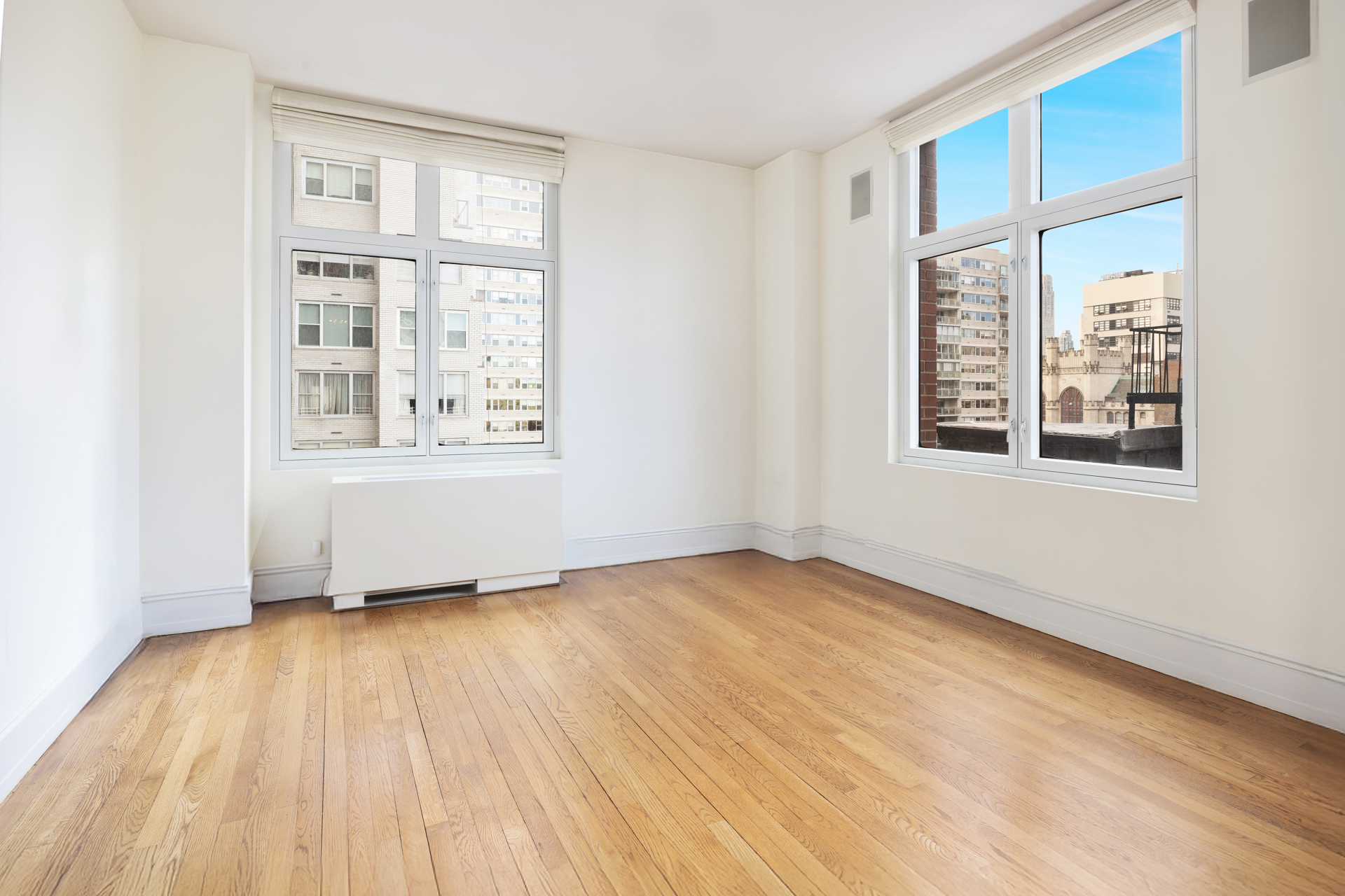 188 East 70th Street, Unit 11D Manhattan, NY 10021 - Photo 11 of 14 an empty room with wooden floor and windows