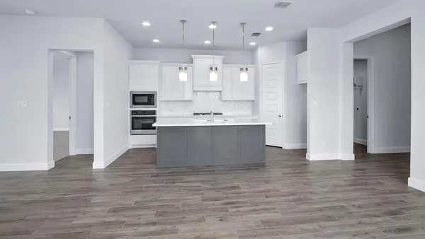 a view of kitchen with kitchen island stainless steel appliances sink and cabinets