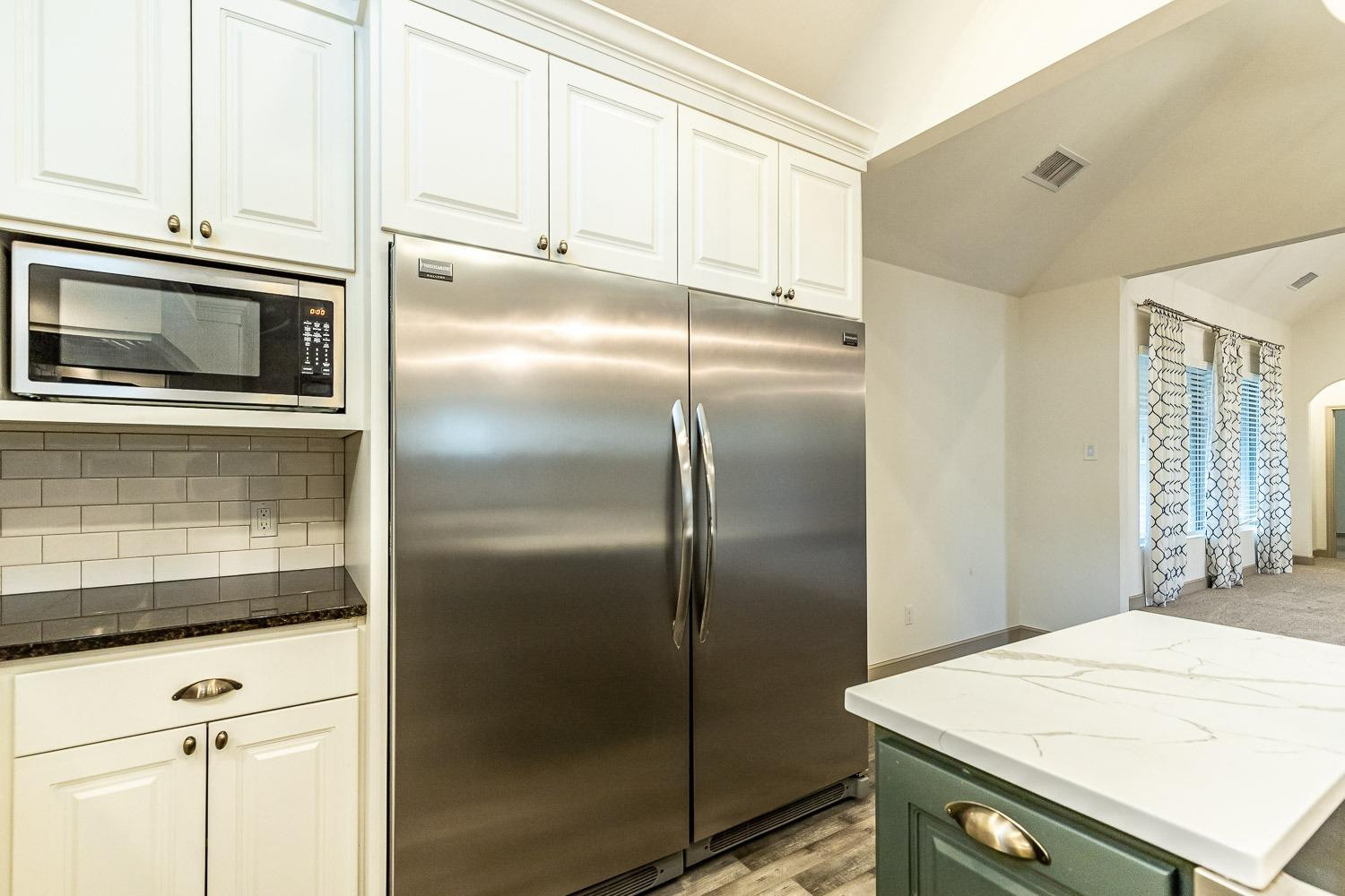 3633 133rd Street Lubbock, TX 79423 - Photo 13 of 46 a kitchen with granite countertop a refrigerator and a sink