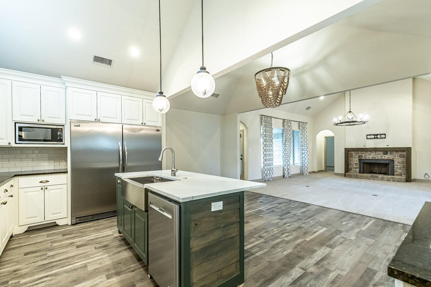 3633 133rd Street Lubbock, TX 79423 - Photo 19 of 46 a kitchen with stainless steel appliances granite countertop a refrigerator a oven a sink and a chandelier