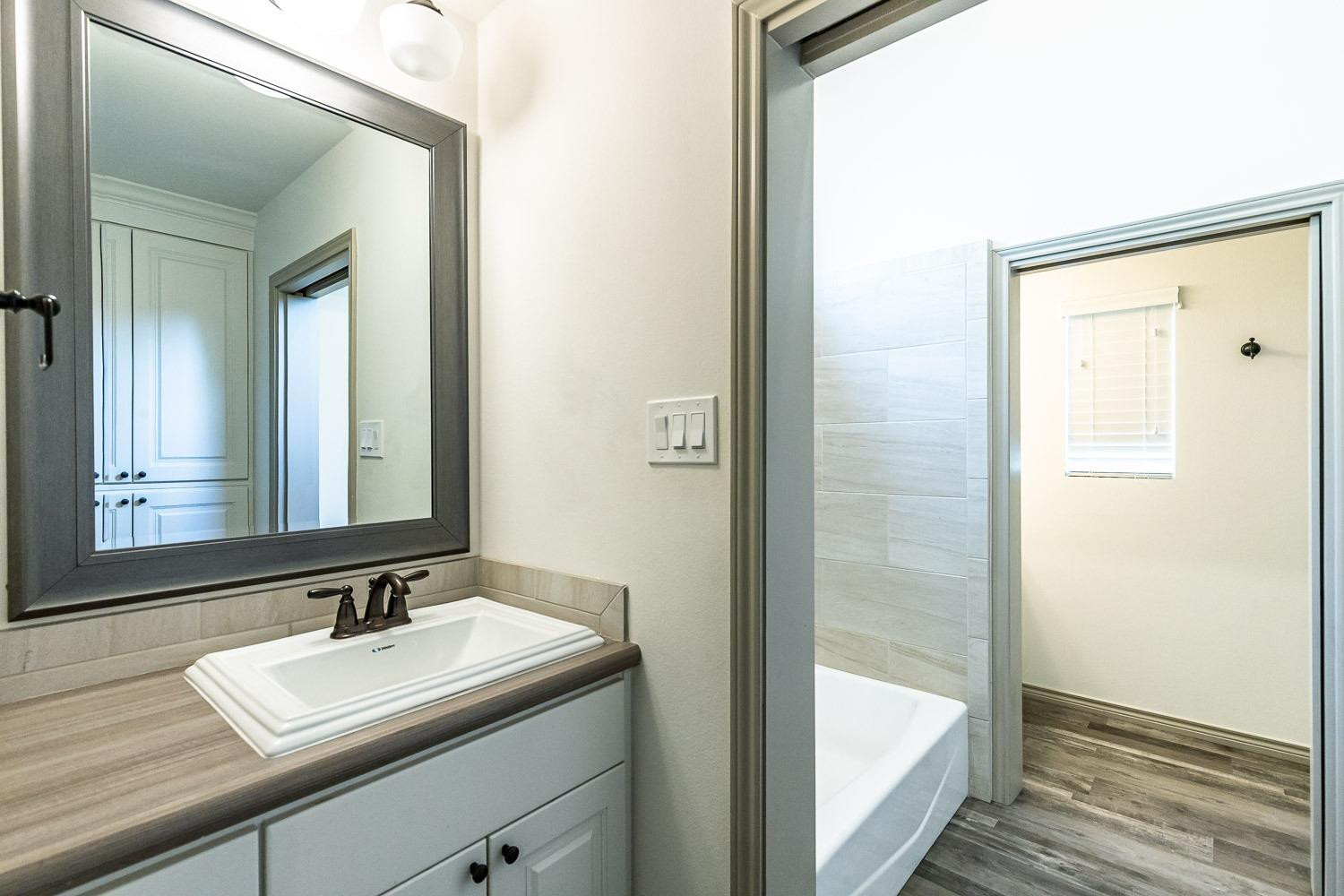 3633 133rd Street Lubbock, TX 79423 - Photo 29 of 46 a bathroom with a sink and a mirror