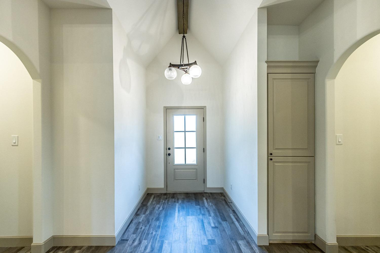 3633 133rd Street Lubbock, TX 79423 - Photo 3 of 46 an empty room with wooden floor cabinet and windows