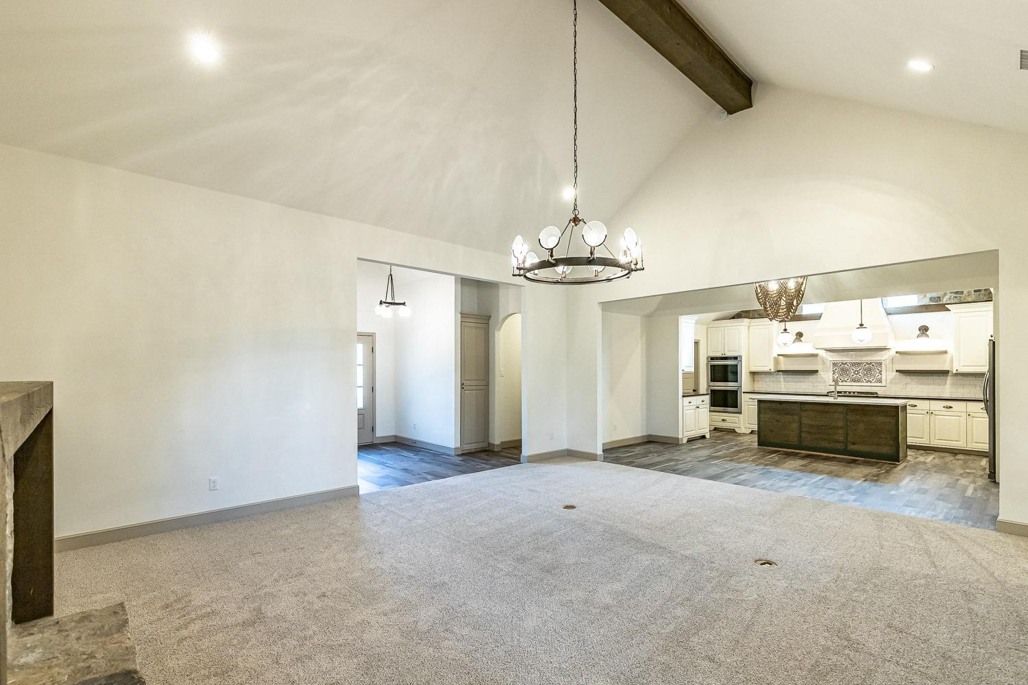 3633 133rd Street Lubbock, TX 79423 - Photo 9 of 46 a view of a livingroom with a chandelier & a kitchen