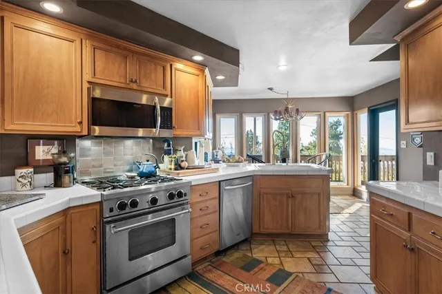 a kitchen with stainless steel appliances granite countertop a stove sink microwave and cabinets