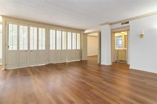 an empty room with wooden floor and windows