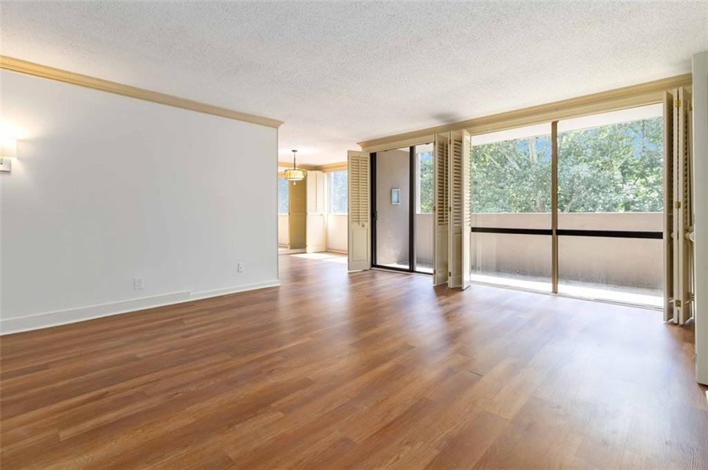 3530 Piedmont Road Northeast, Unit 5A Atlanta, GA 30305 - Photo 13 of 47 a view of an empty room with wooden floor and a window