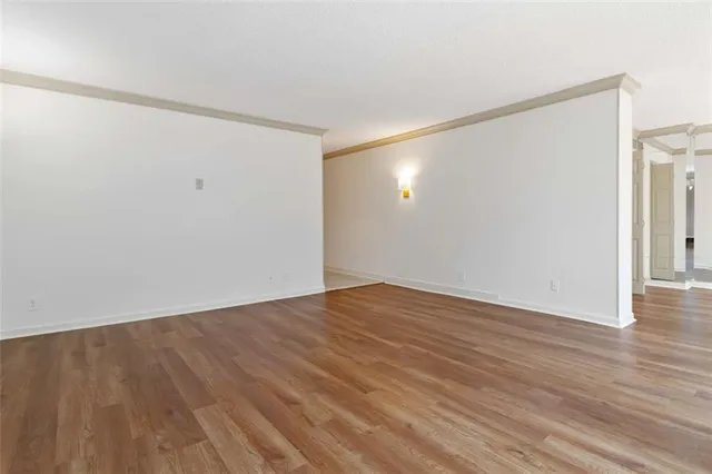 a view of an empty room with wooden floor