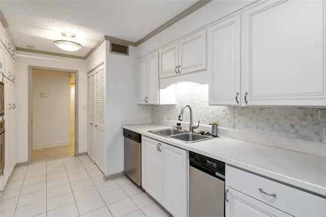 a kitchen with a sink dishwasher and cabinets