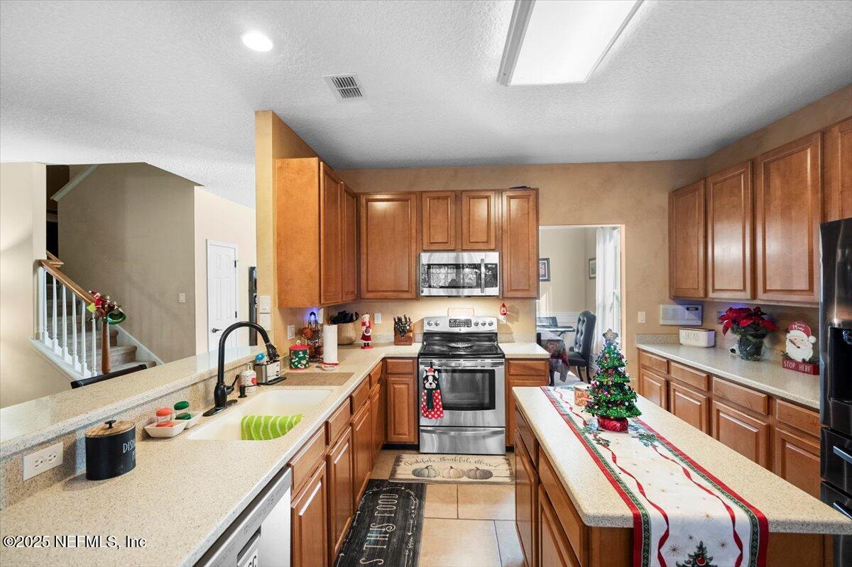 2493 Tall Cedars Road Fleming Island, FL 32003 - Photo 14 of 68 a kitchen with stainless steel appliances a sink stove and cabinets
