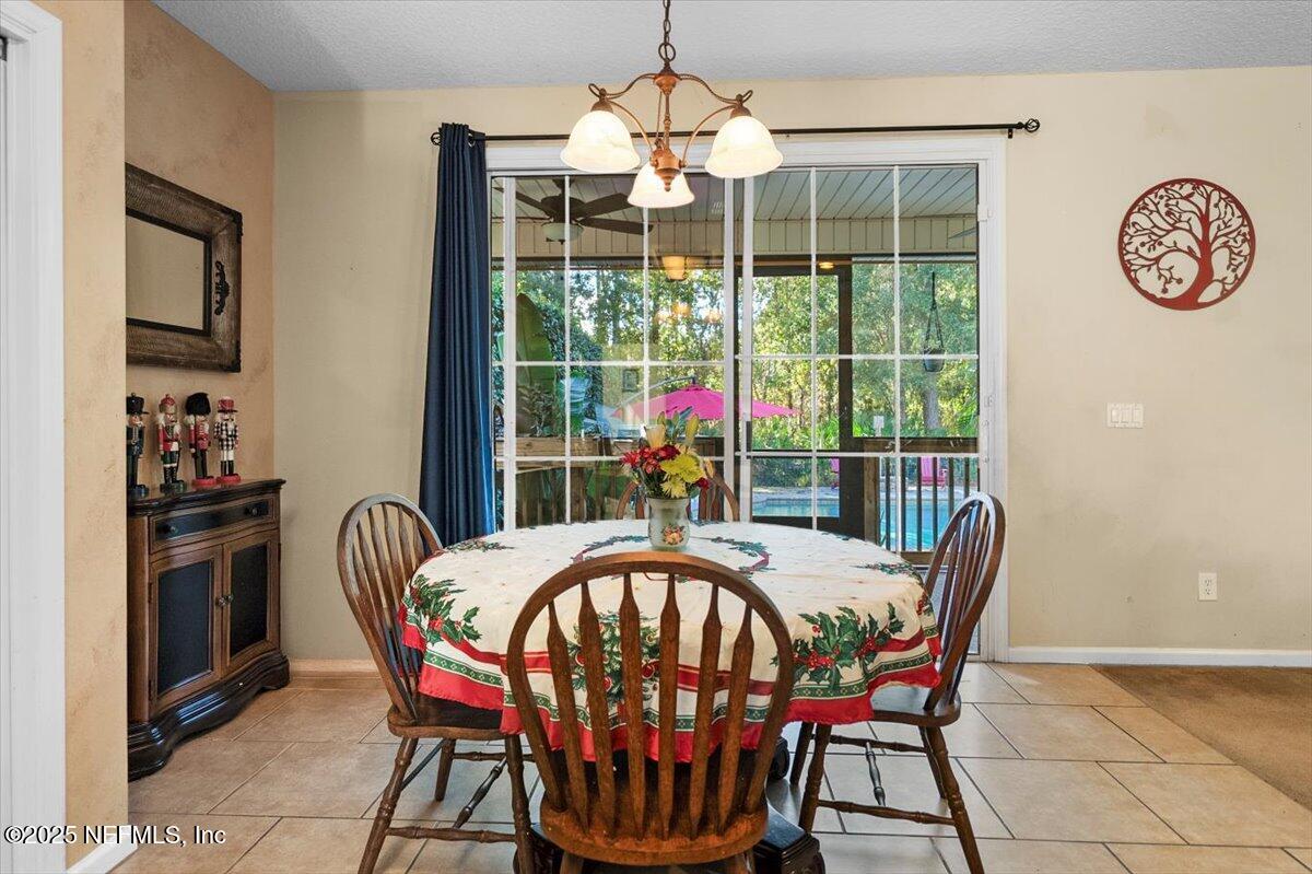 2493 Tall Cedars Road Fleming Island, FL 32003 - Photo 16 of 68 a dining room with furniture a chandelier and window