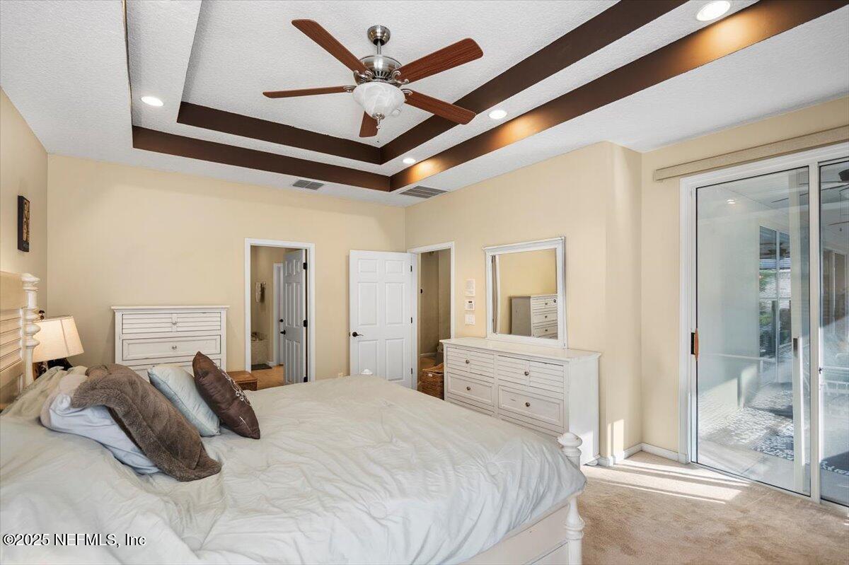 2493 Tall Cedars Road Fleming Island, FL 32003 - Photo 20 of 68 a bedroom with a large bed and a chandelier