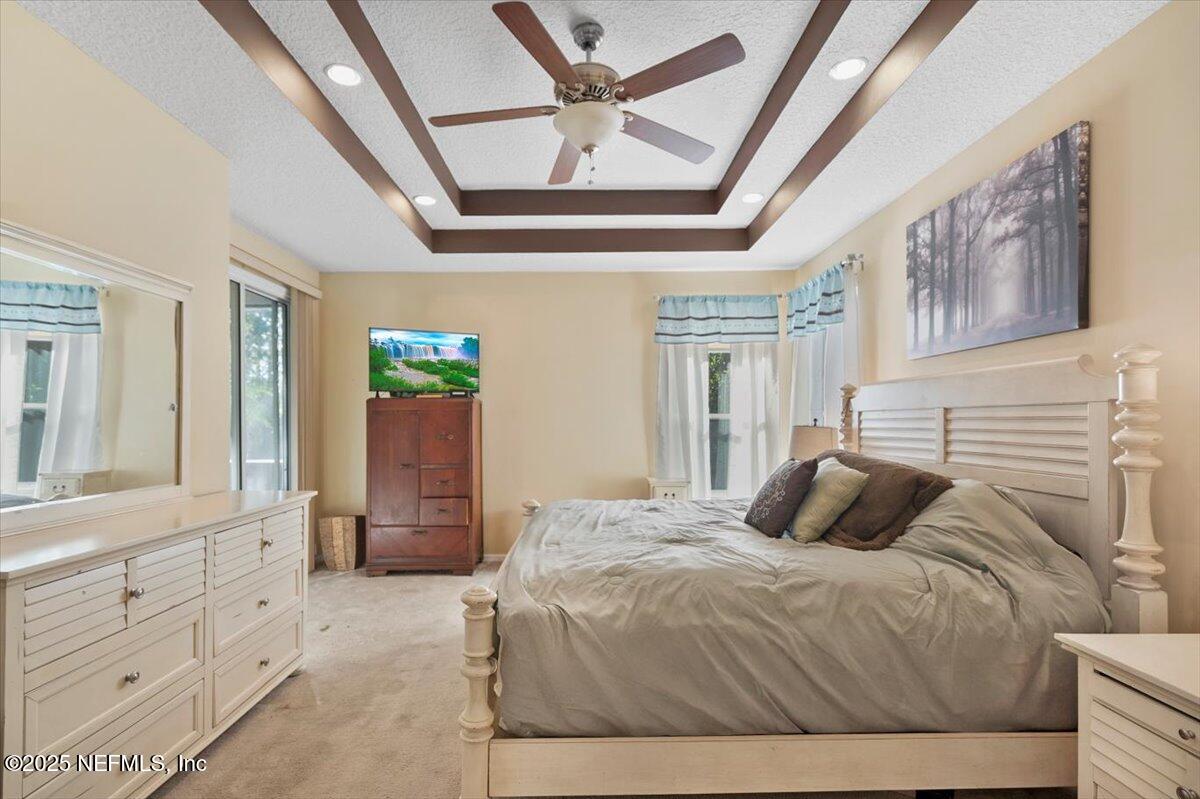 2493 Tall Cedars Road Fleming Island, FL 32003 - Photo 21 of 68 a bedroom with a bed and a chandelier