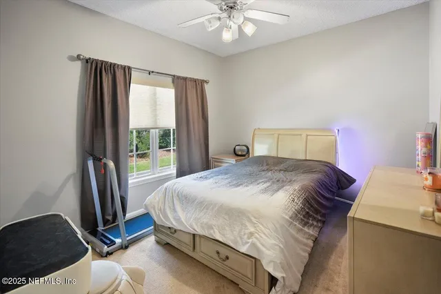 a bedroom with a bed a chandelier and a window