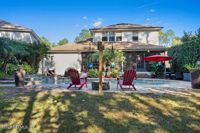 a front view of a house with a yard and palm trees