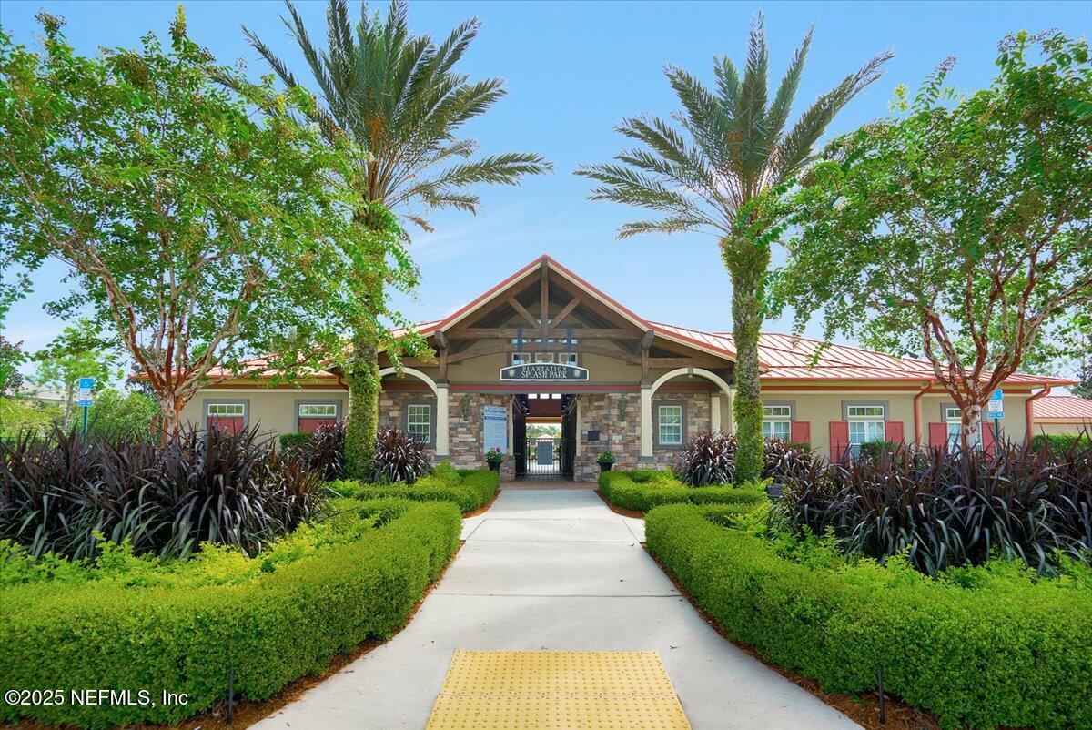2493 Tall Cedars Road Fleming Island, FL 32003 - Photo 49 of 68 a front view of a house with a yard and potted plants