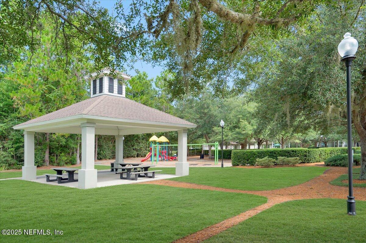 2493 Tall Cedars Road Fleming Island, FL 32003 - Photo 64 of 68 a view of a patio with table and chairs under an umbrella