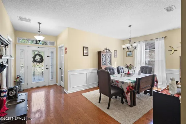 a view of a dining room with furniture and chandelier
