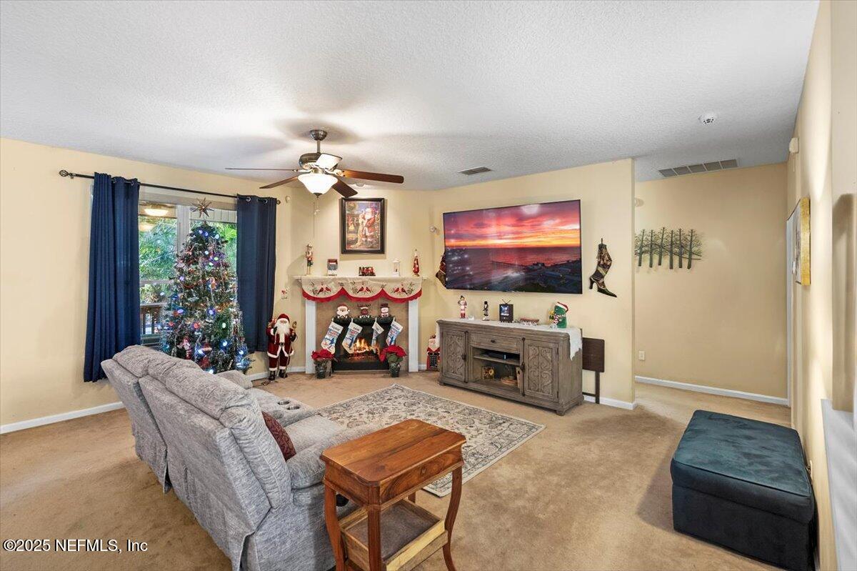 2493 Tall Cedars Road Fleming Island, FL 32003 - Photo 9 of 68 a living room with furniture a flat screen tv and a fireplace
