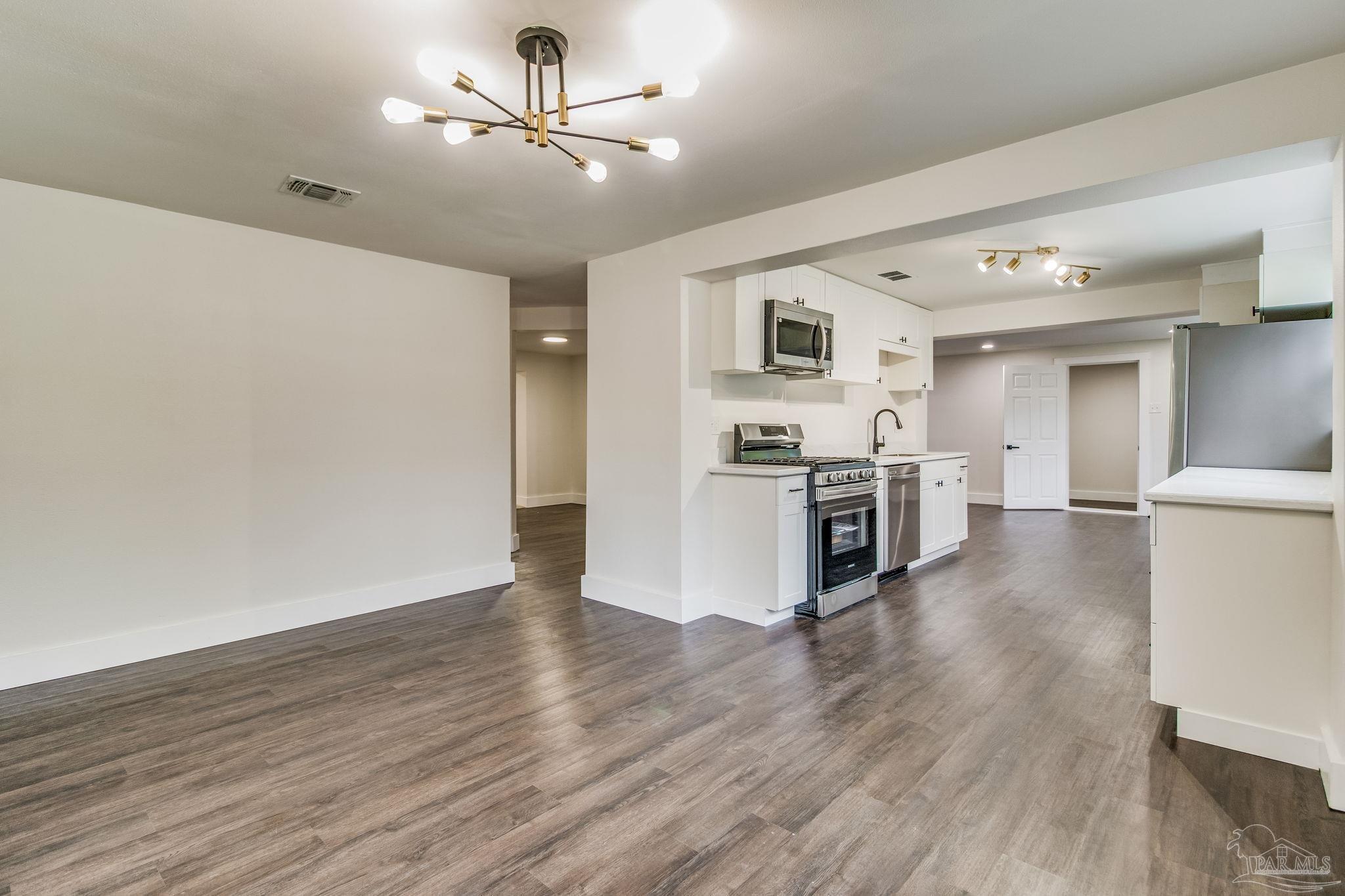 4355 Highway 95A North Molino, FL 32577 - Photo 13 of 54 a view of a kitchen with a sink a refrigerator and wooden floor