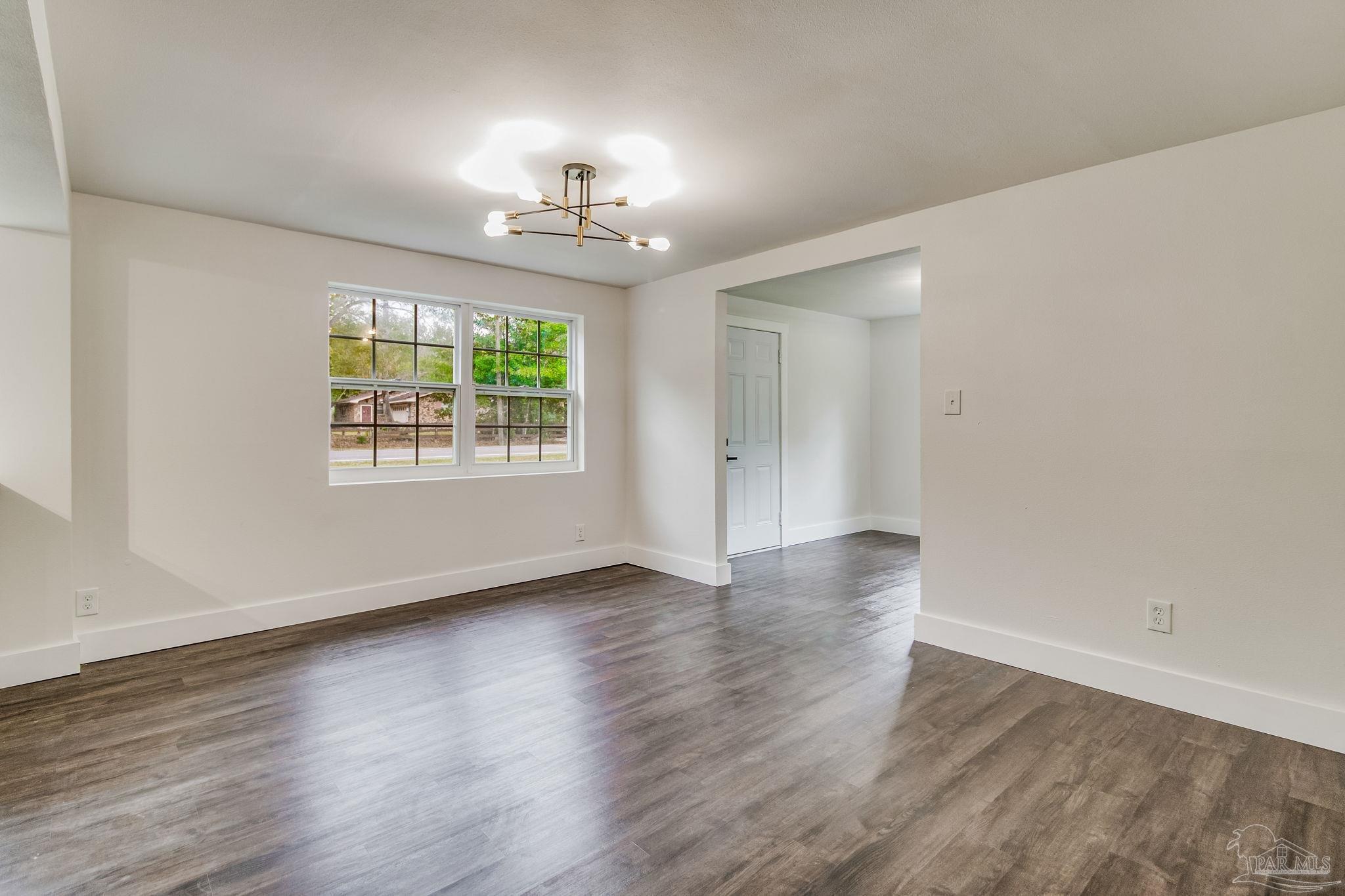 4355 Highway 95A North Molino, FL 32577 - Photo 15 of 54 an empty room with wooden floor chandelier and windows