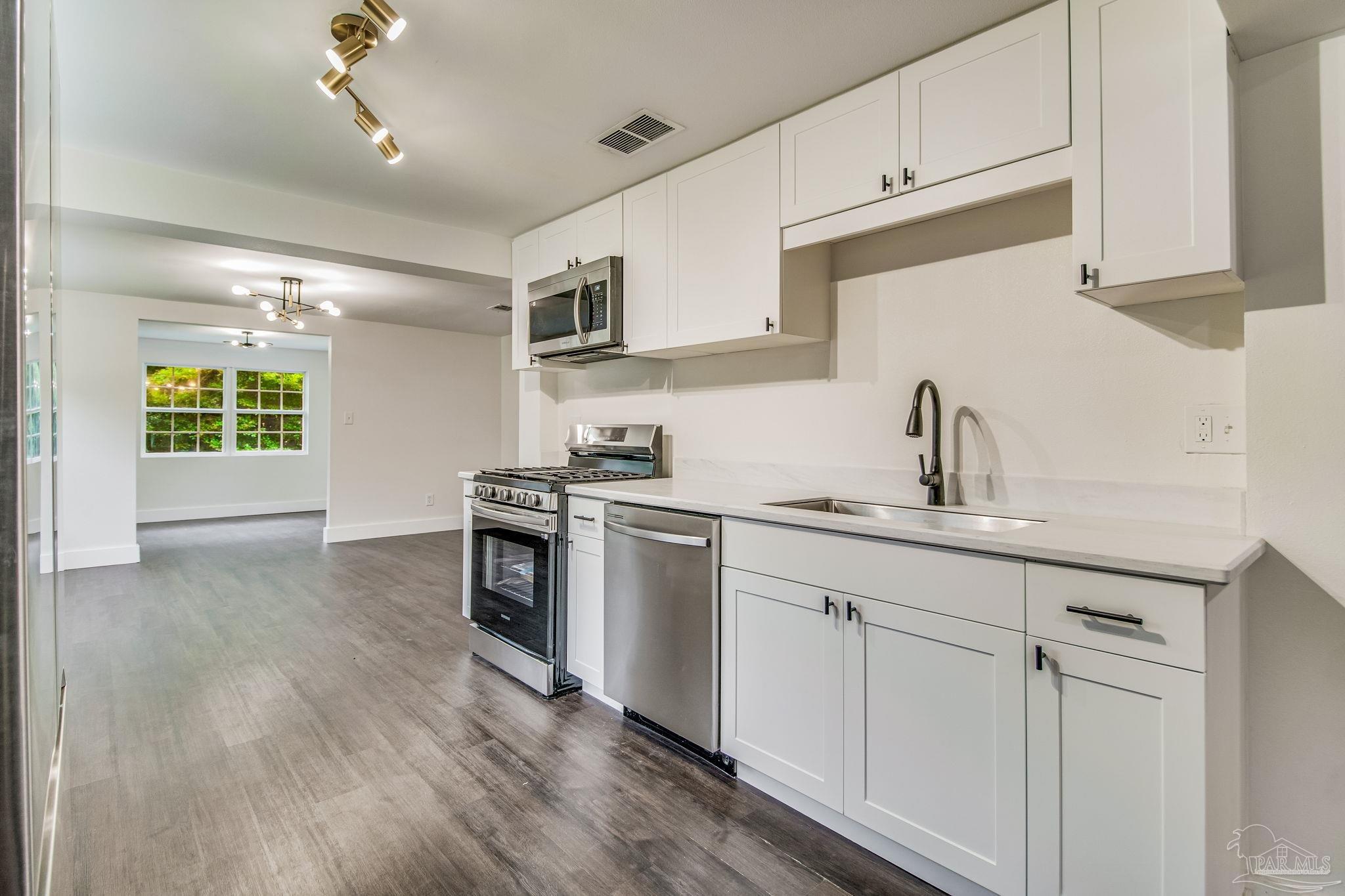 4355 Highway 95A North Molino, FL 32577 - Photo 19 of 54 a kitchen with a sink cabinets stainless steel appliances and a window