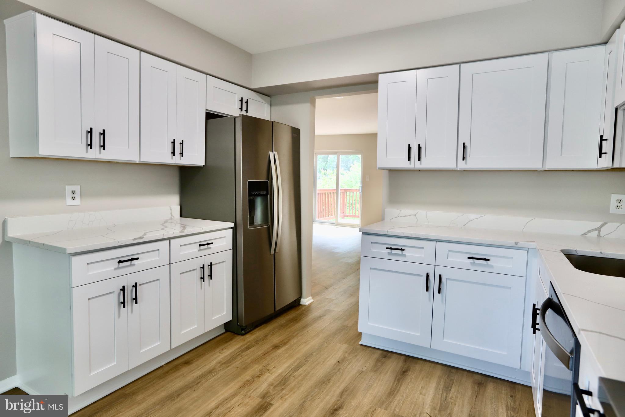 7442 Broken Staff Columbia, MD 21045 - Photo 4 of 28 a kitchen with white cabinets and stainless steel appliances