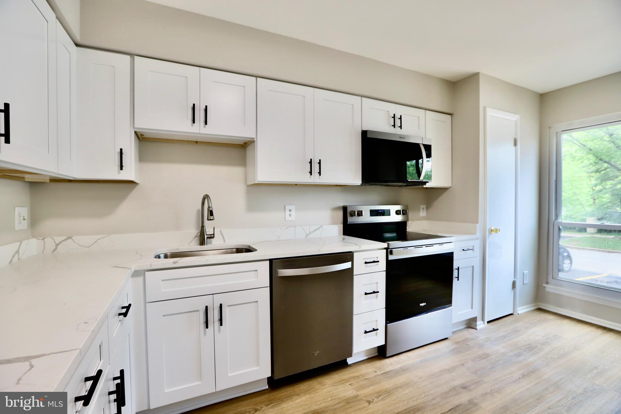 7442 Broken Staff Columbia, MD 21045 - Photo 5 of 28 a kitchen with stainless steel appliances granite countertop a stove a sink and white cabinets